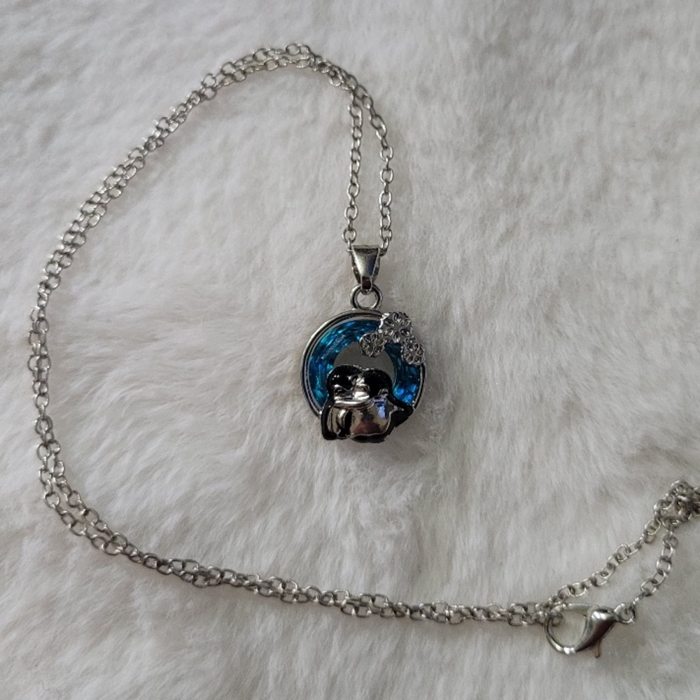 Light blue circle with penguin hugging necklace ￼